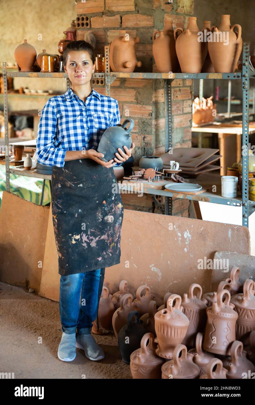 Female artisan in apron having ceramics in stock Stock Photo Alamy