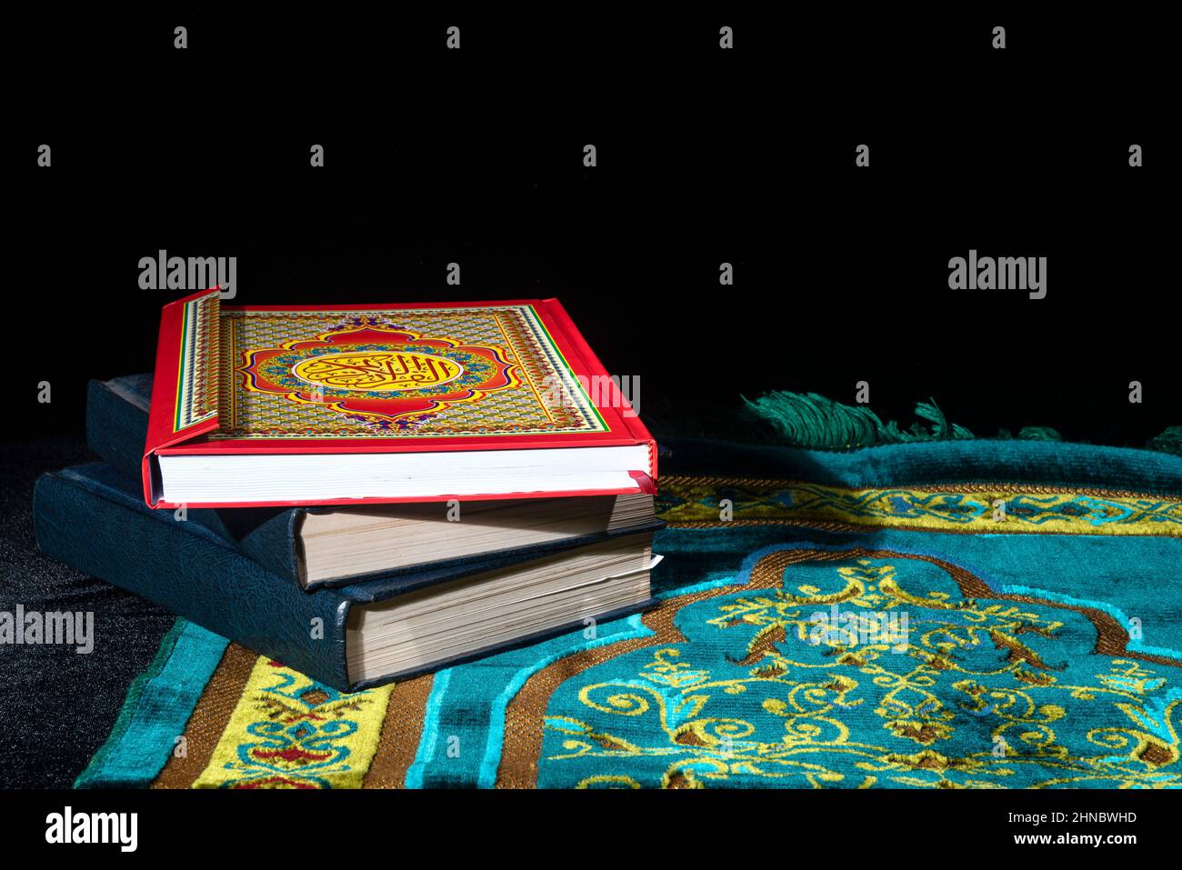 Quran on a prayer rug with dark background Stock Photo Alamy