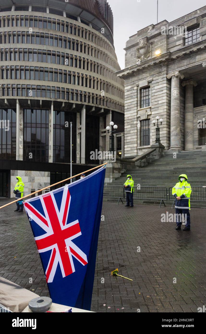 Wellington, New Zealand. February 13, 2022: An upside-down NZ flag hangs across the barriers at Parliament during the anti-mandate convoy occupation p Stock Photo