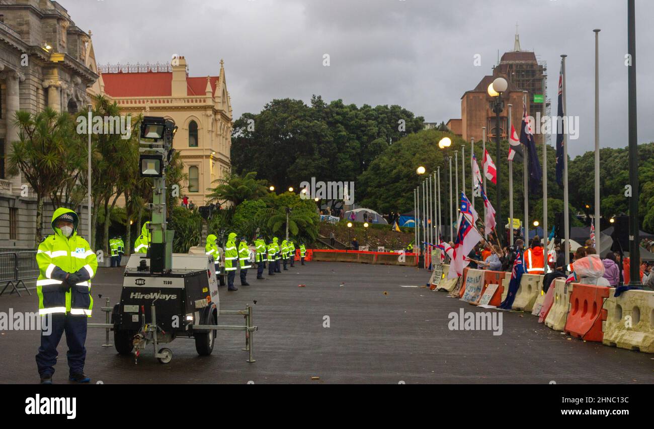Wellington, New Zealand. February 13, 2022: Police line up facing the front line of the covid anti-mandate convoy protest and occupation of Parliament Stock Photo
