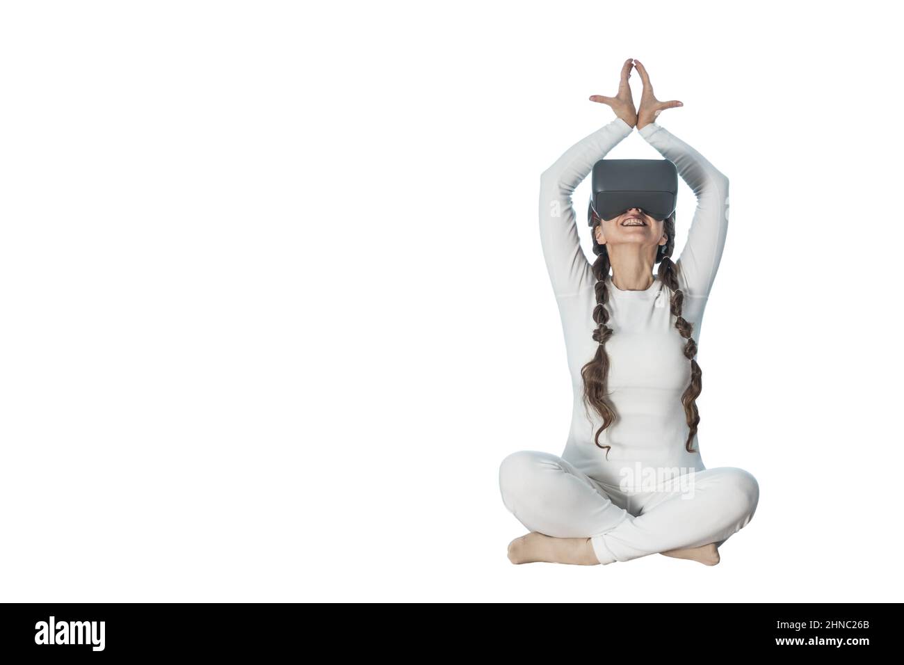 A woman does yoga with virtual reality glasses. She takes various yoga