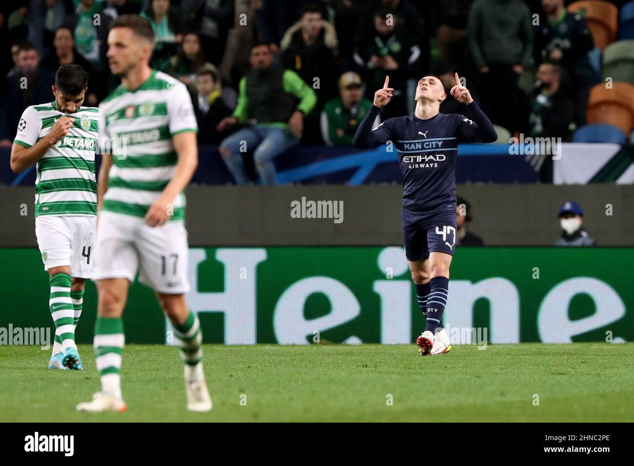 Lisbon, Portugal. 15th Feb, 2022. Phil Foden of Manchester City (R) celebrates after scoring a goal during UEFA Champions League round of 16 first leg match between Sporting CP and Manchester City at Alvalade stadium in Lisbon, Portugal, on Feb. 15, 2022. Credit: Pedro Fiuza/Xinhua/Alamy Live News Stock Photo