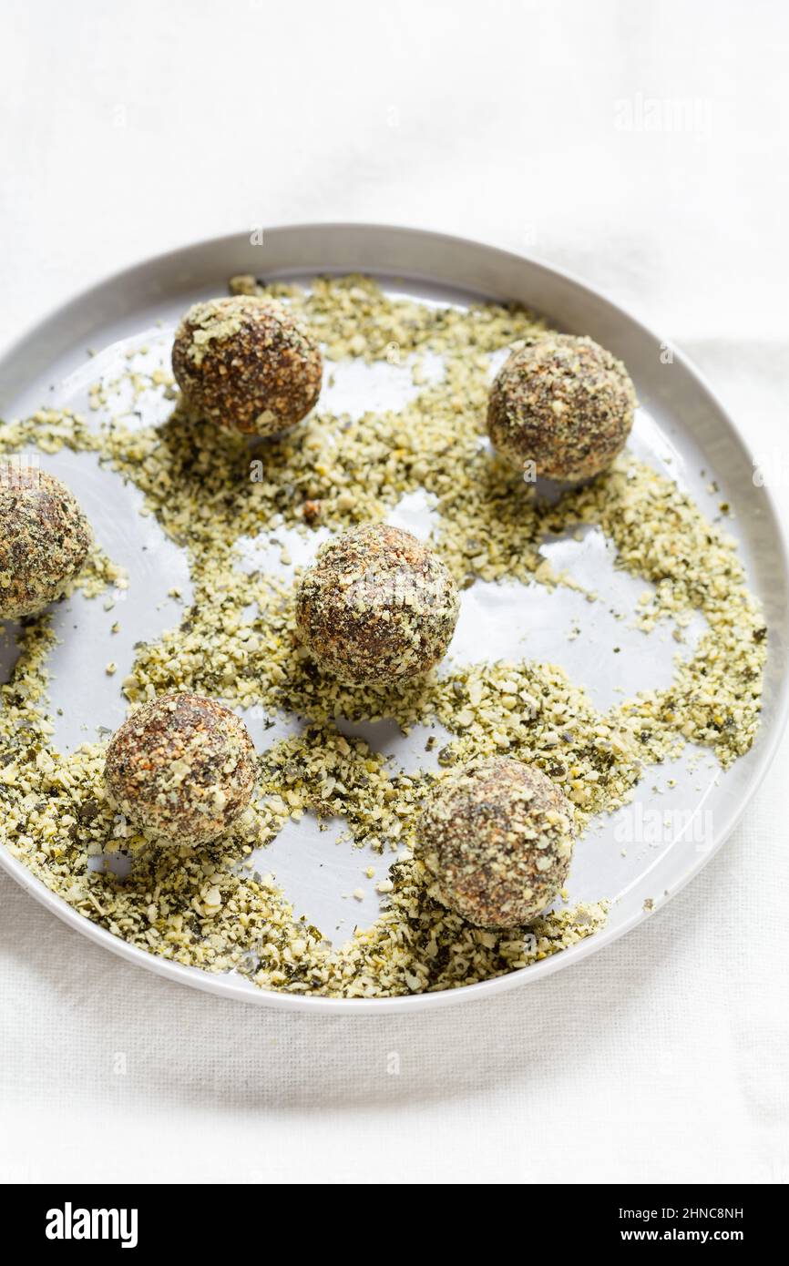 Dates and nuts energy balls rolled in pumpkin seeds fine dust Stock