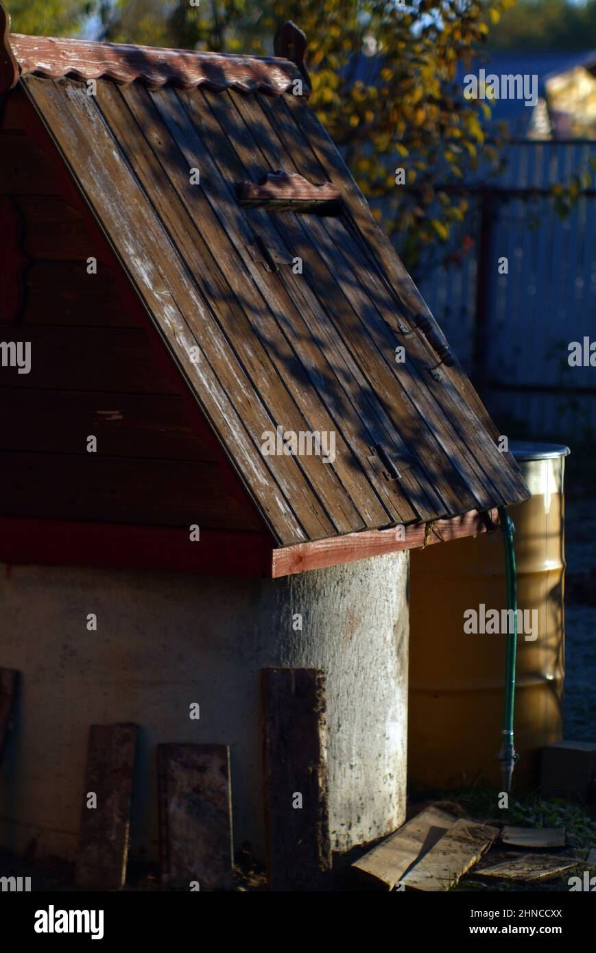 well with wooden roof in the garden, early morning Stock Photo