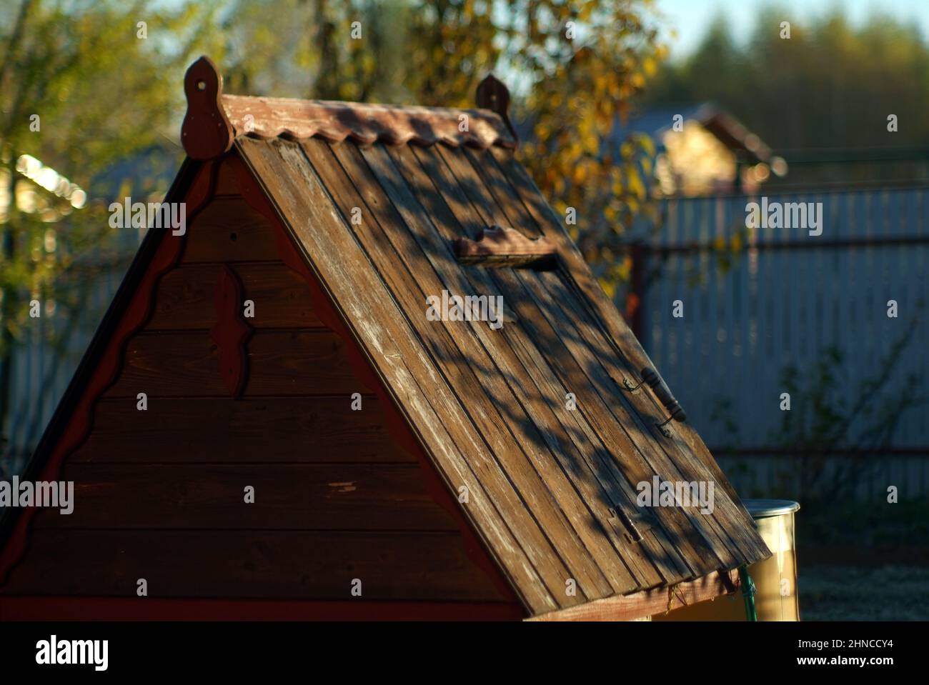 well with wooden roof in the garden, early morning Stock Photo