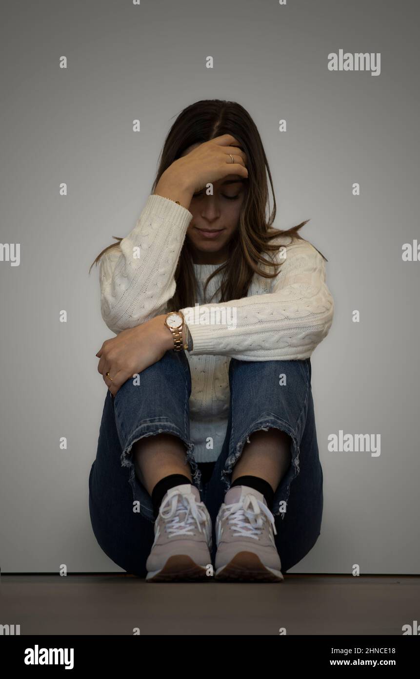 Lonely young woman feeling depressed and stressed sitting head in hands