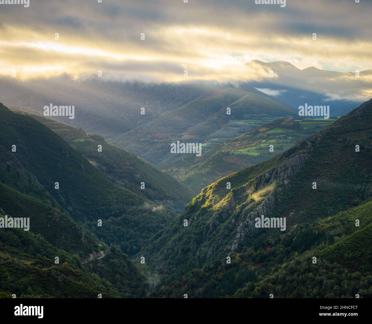 Dawn light floods deep valleys and farmland next to small villages in Cervantes Ancares in Galicia Stock Photo