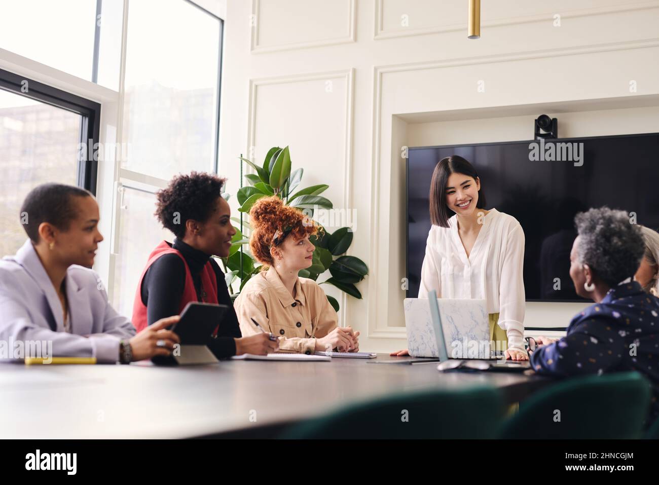 Mid adult Chinese woman in business meeting with multi ethnic colleagues Stock Photo