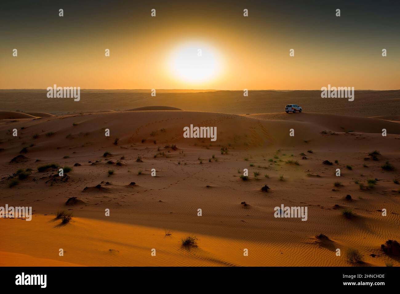 After the trip by off-road car in the sand dunes, we enjoy now the sunset in Wahiba sand, Oman Stock Photo