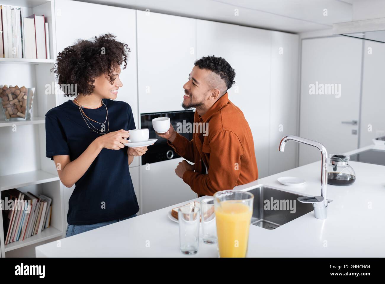 happy african american couple holding cups of coffee in kitchen Stock ...