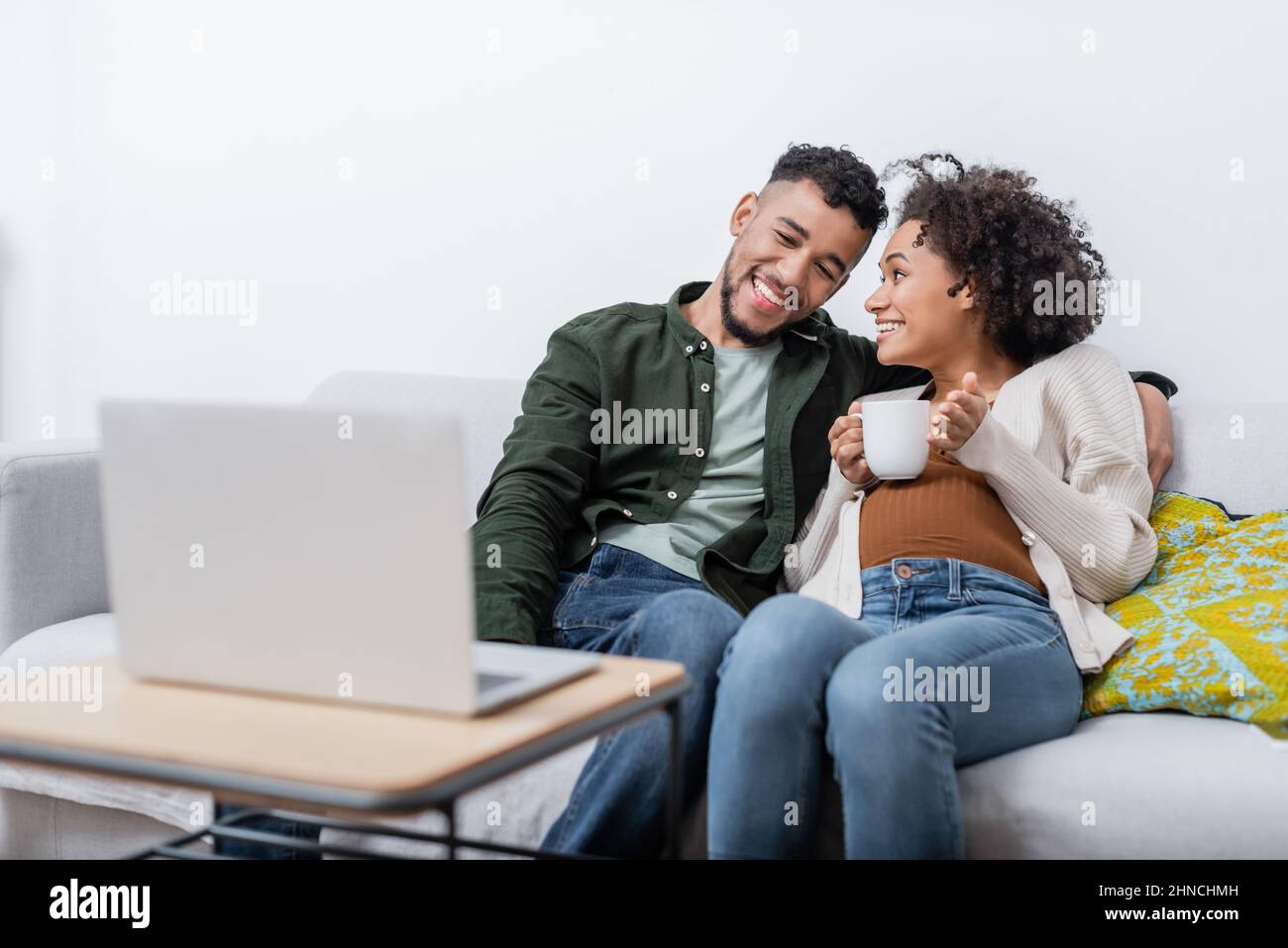 happy african american husband and pregnant wife watching movie on ...