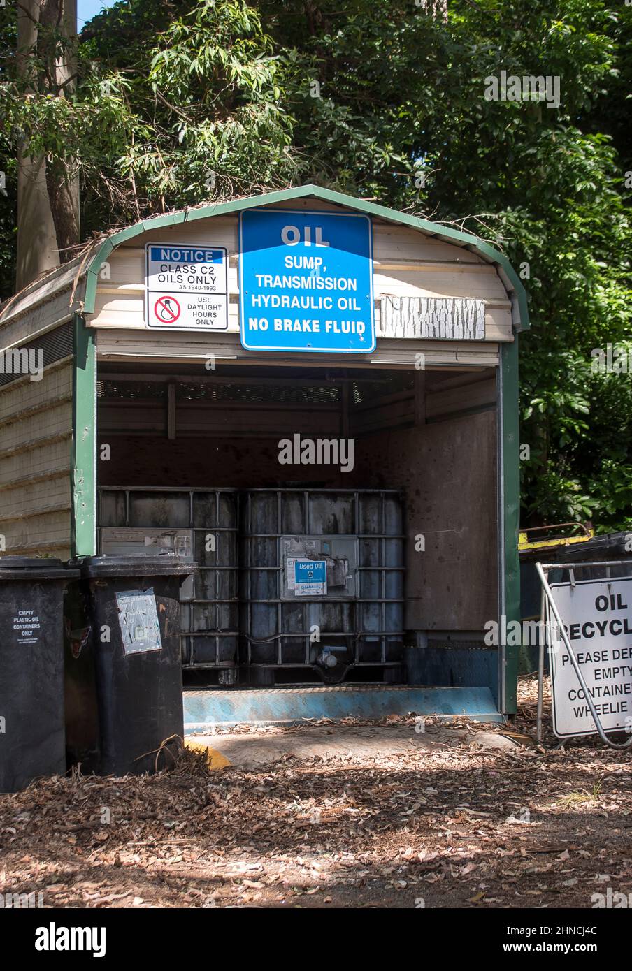 Waste oil disposal facility at small rural recycling site in Queensland, Australia. Notice boards of instructions. Small hut in rainforest setting. Stock Photo