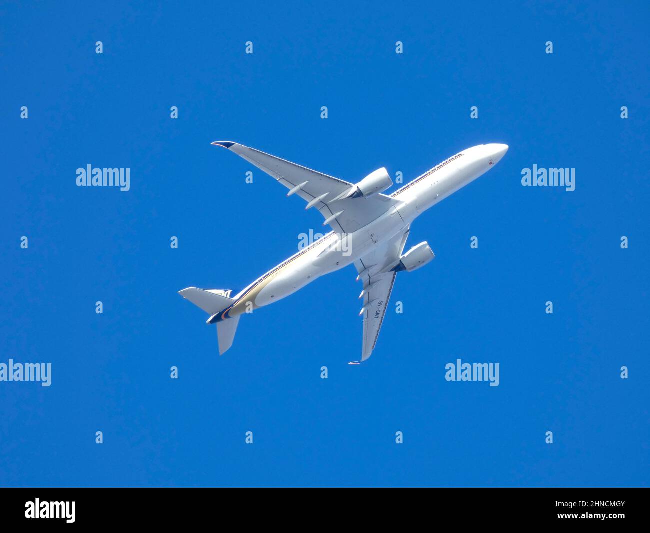 Commercial passenger aircraft flying over blue sky Stock Photo