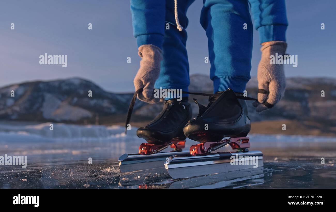 The child train on ice speed skating. Athlete puts on skates. The girl