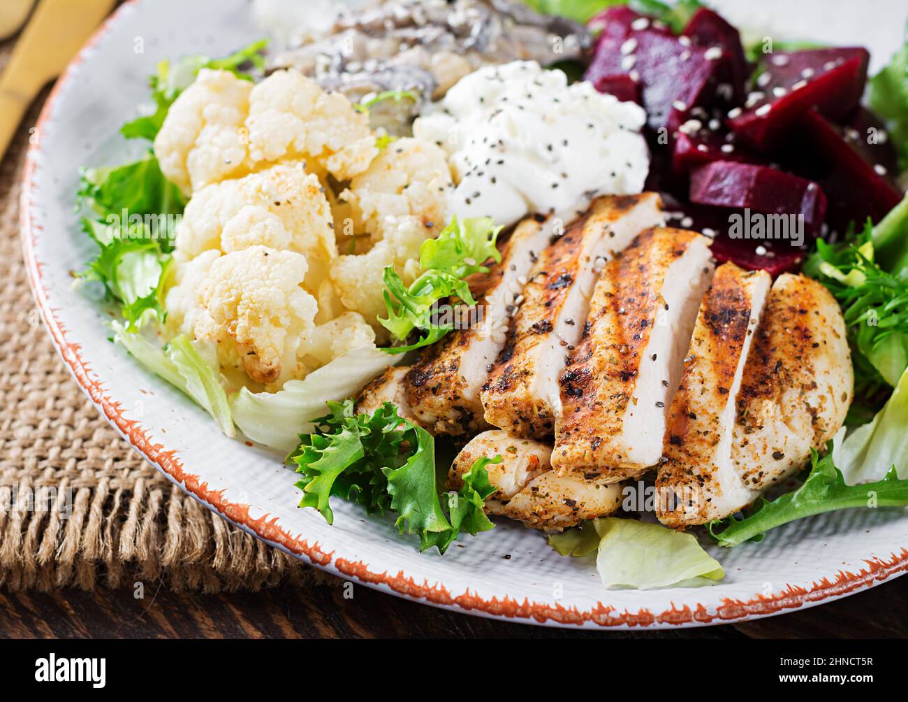 Healthy lunch. Boiled beetroot salad with greens, stewed mushrooms,  and grilled chicken fillet and baked cauliflower. Dinner. Stock Photo