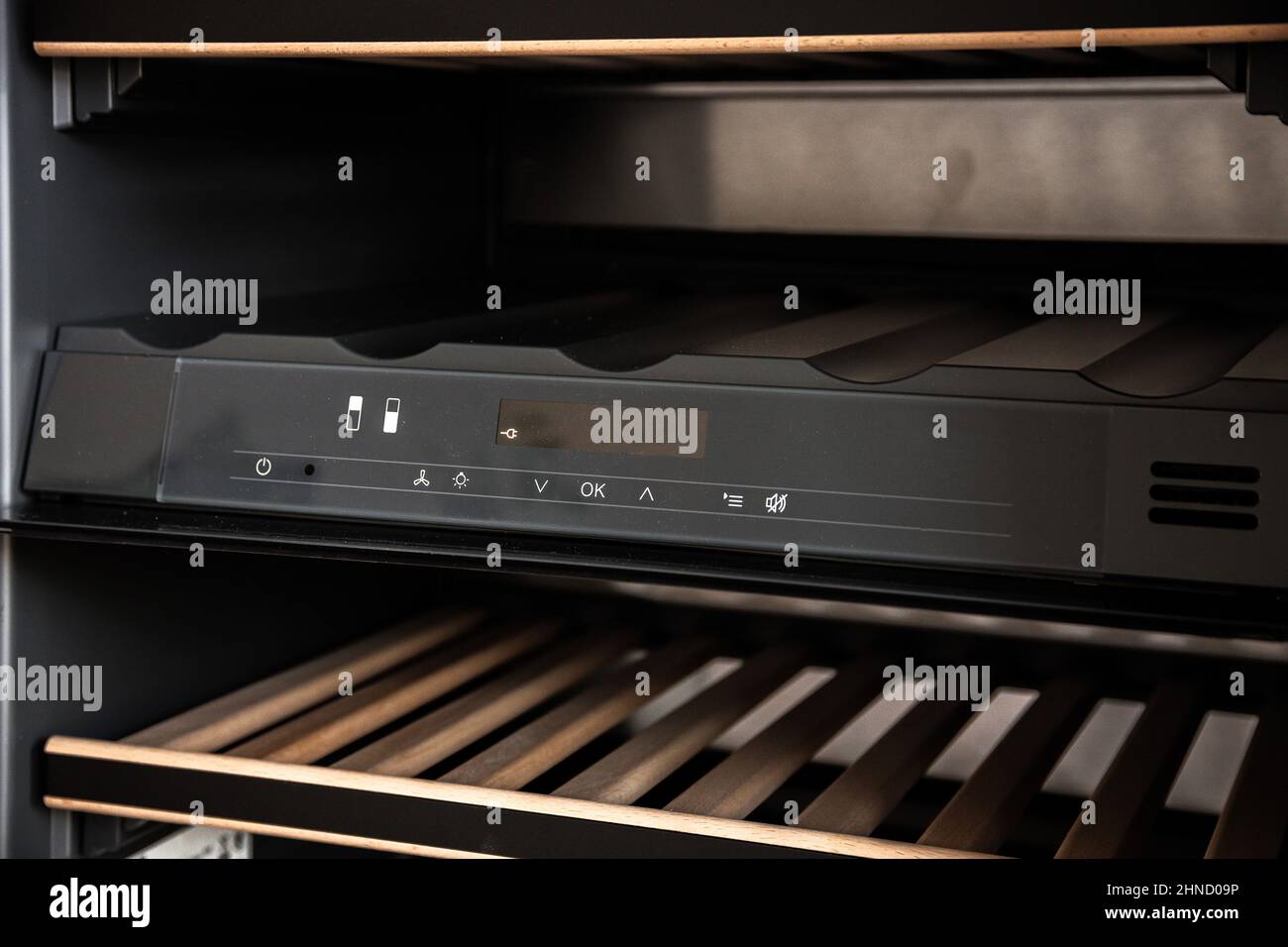 Part of modern stylish black wine refrigerator with wooden cooler rack