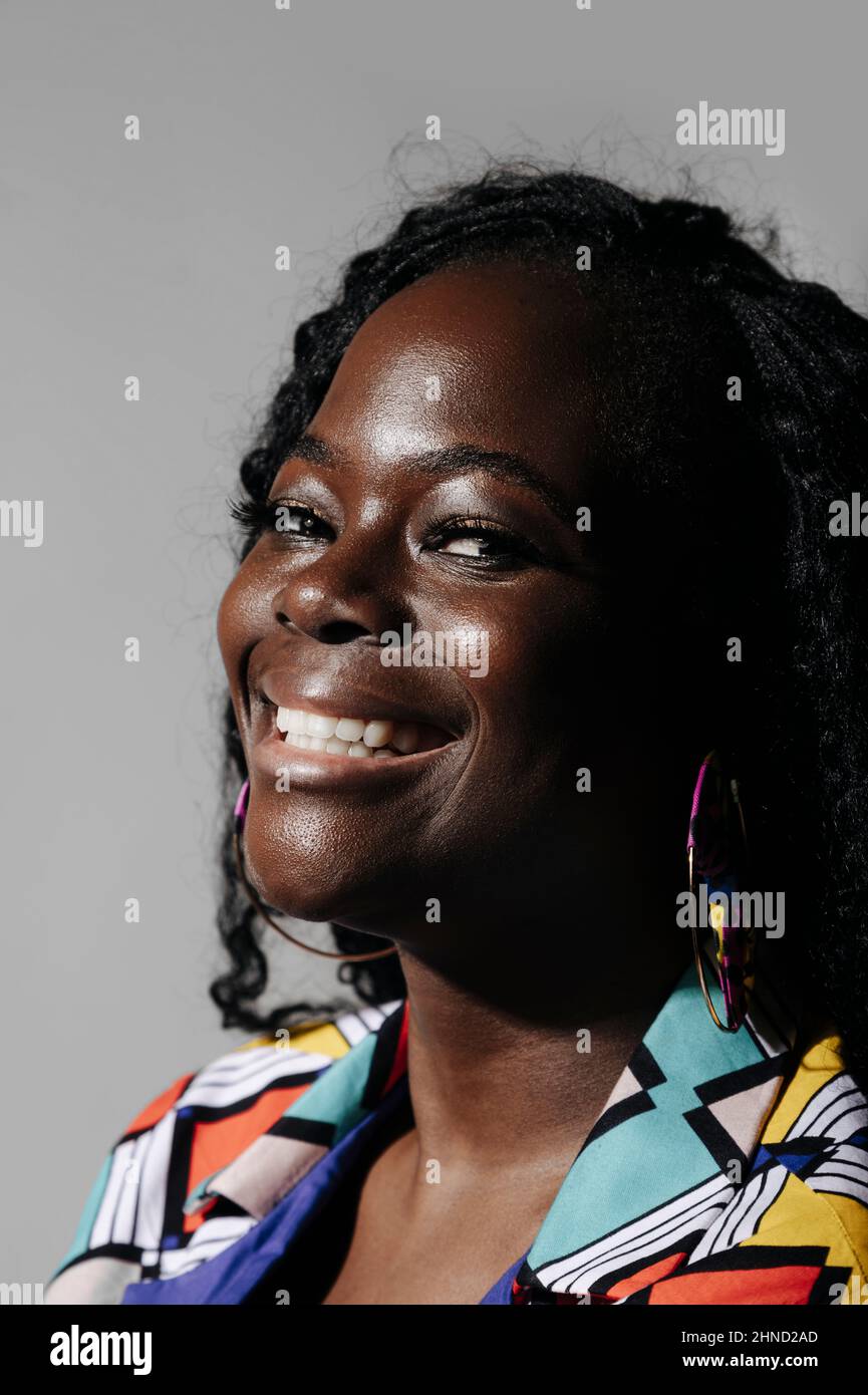 Happy African American Woman with curly hair smiling and looking at ...