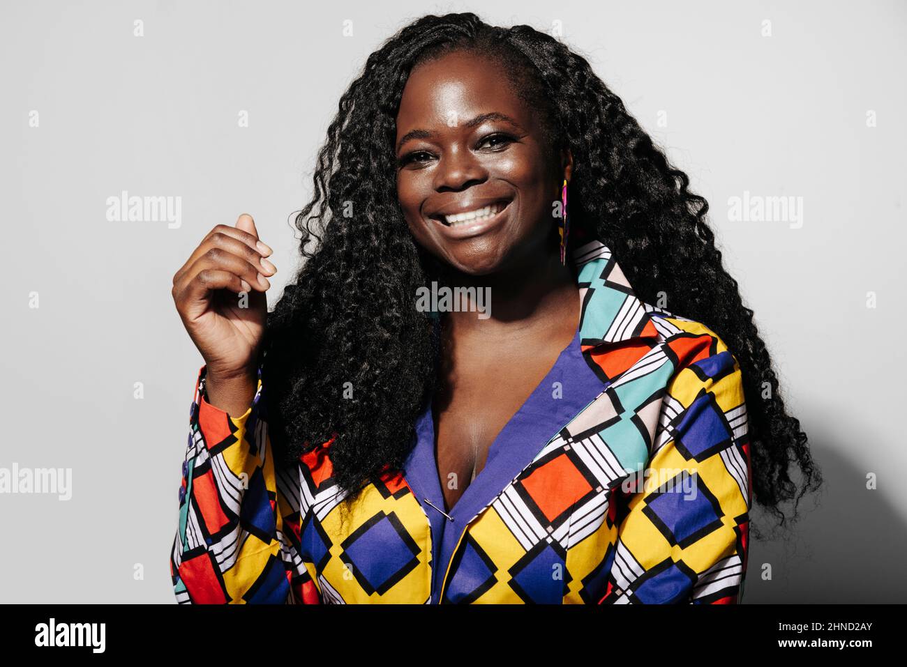 Happy African American Woman with curly hair smiling at camera while ...