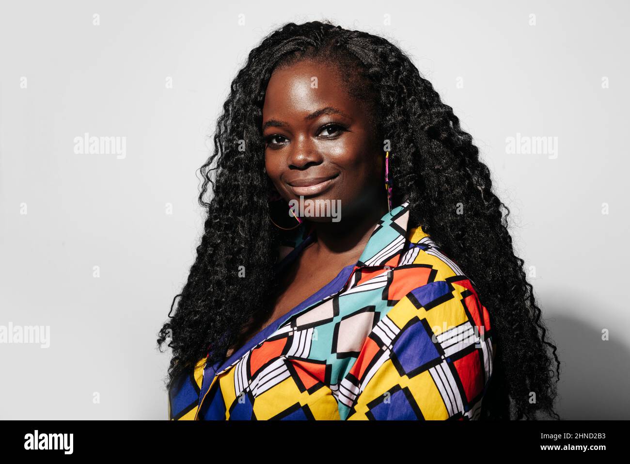 Happy African American Woman with curly hair smiling and looking at ...