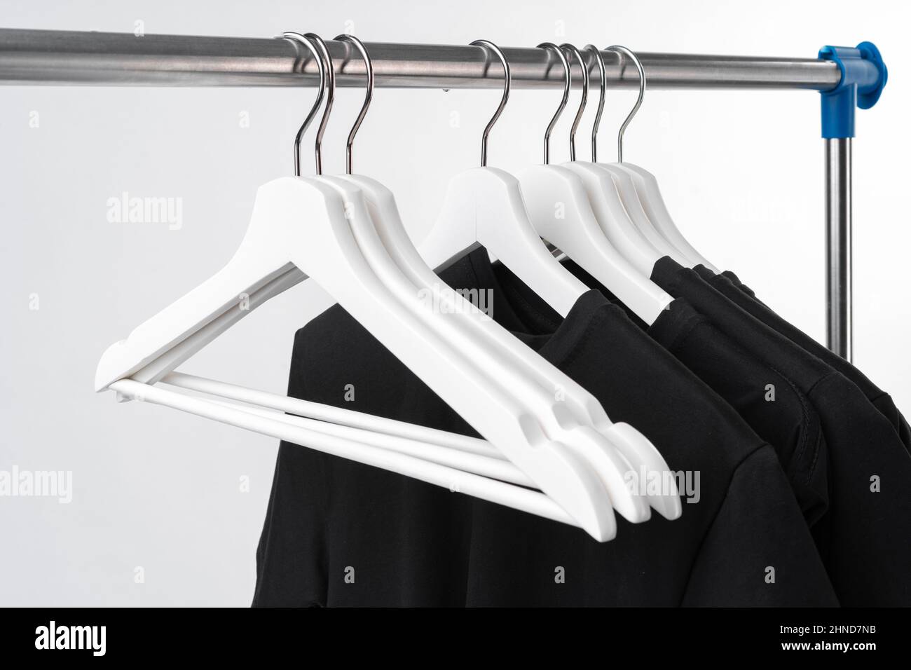 Black Tshirt on hangers on metal rack isolated on white background Stock Photo Alamy