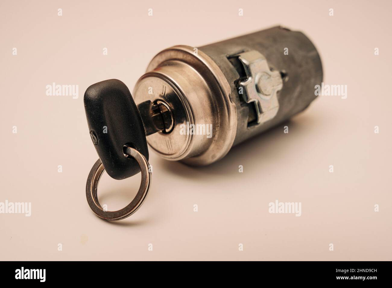 car ignition lock with key on pink background, spare parts, repair kit