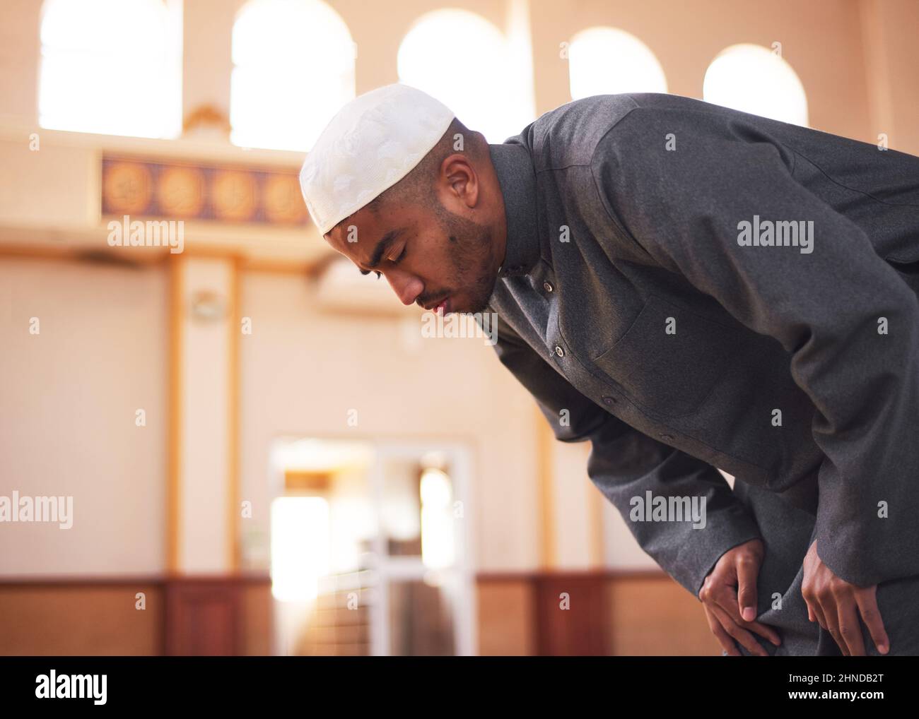 A side view of a Muslim man bowing during prayers at a mosque  Stock Photo
