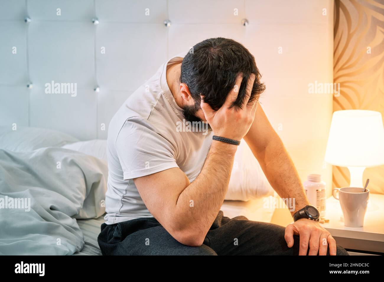 person with some kind of problem sitting on the bed and shaking their