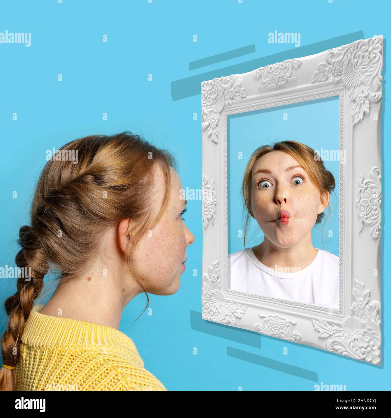 Young girl looking at mirror isolated on light background. Contemporary