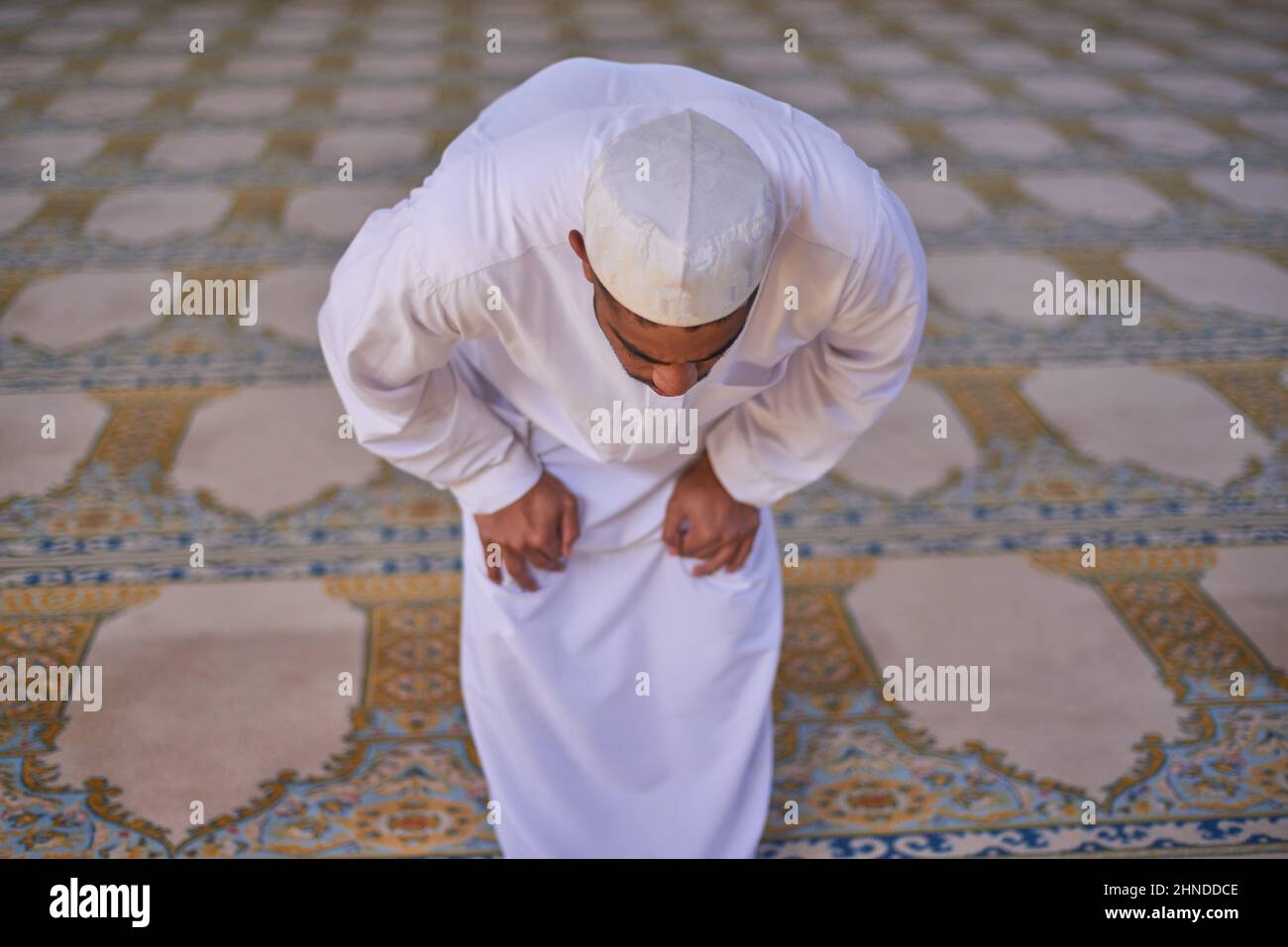 A Muslim man bowing during prayers at a mosque Stock Photo