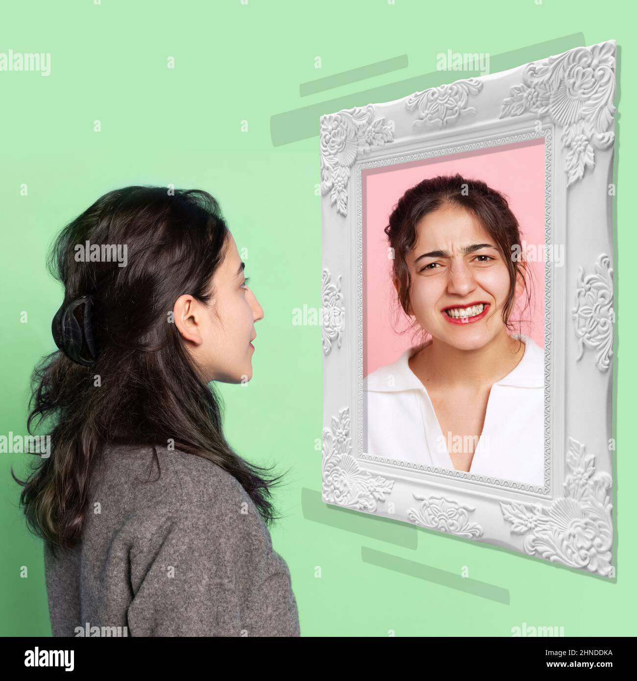 Young girl looking at mirror isolated on light background. Contemporary art collage. Concept of emotions, inner world, mental health Stock Photo
