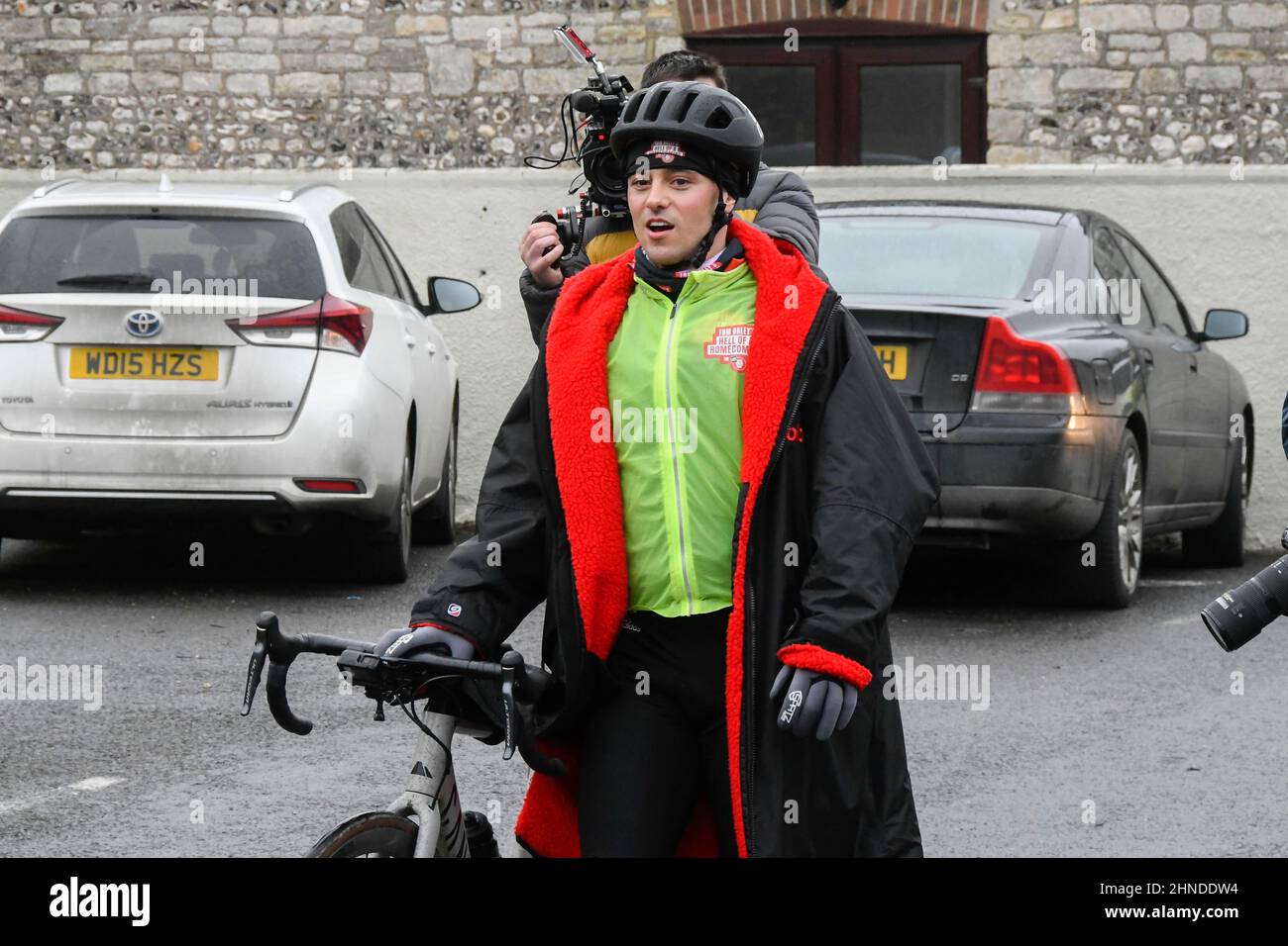 Winterbourne Abbas, Dorset, UK.  16th February 2022.  Olympic gold medalists Tom Daley OBE stops to take a lunch break at Winterbourne Abbas in Dorset on day 3 of his Comic Relief Hell of a Homecoming challenge from the Queen Elizabeth Olympic Park in Stratford to his hometown of Plymouth in Devon.  On this leg he is cycling 130 miles from Southampton to Bovey Castle on Dartmoor in Devon.  Picture Credit: Graham Hunt/Alamy Live News Stock Photo