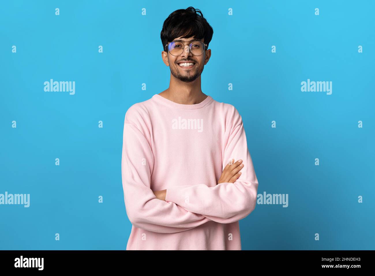 Handsome middle eastern young man posing on blue Stock Photo