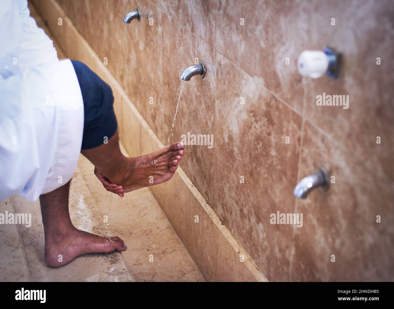 A close up shot of a young Muslim cleansing his feet Stock Photo