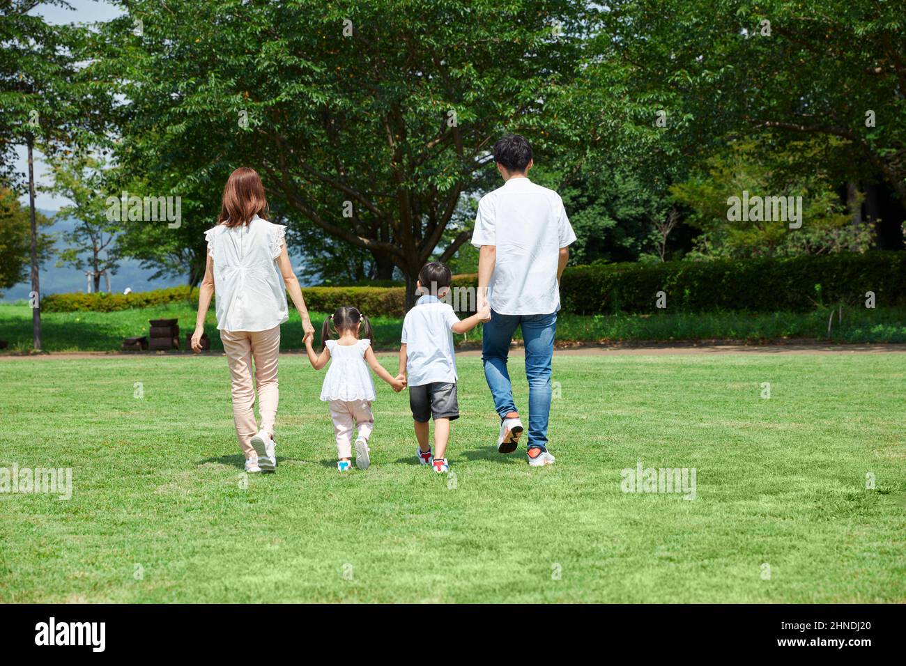 Back View Of Japanese Family Holding Hands Stock Photo