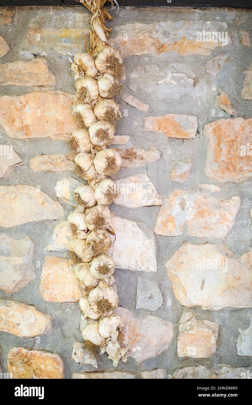 Traditional romanian garlic rope hanging on a stone wall in