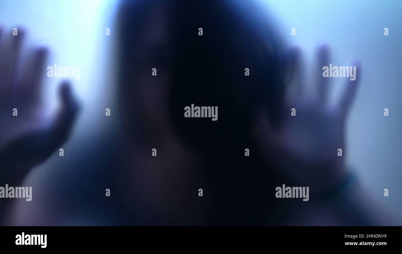Defocused shot of person trapped in emotional problems behind glass ...