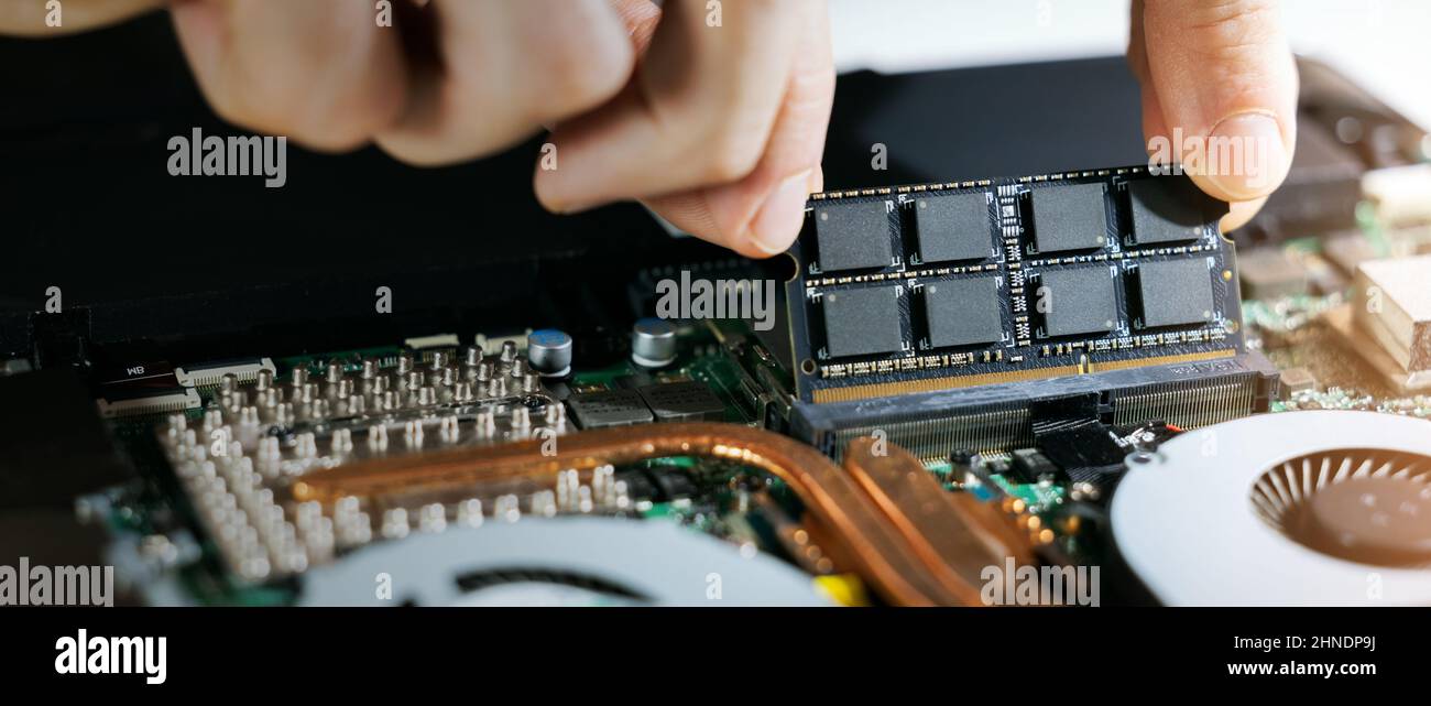 technician installing ram memory module in laptop motherboard. computer hardware upgrade. copy space Stock Photo