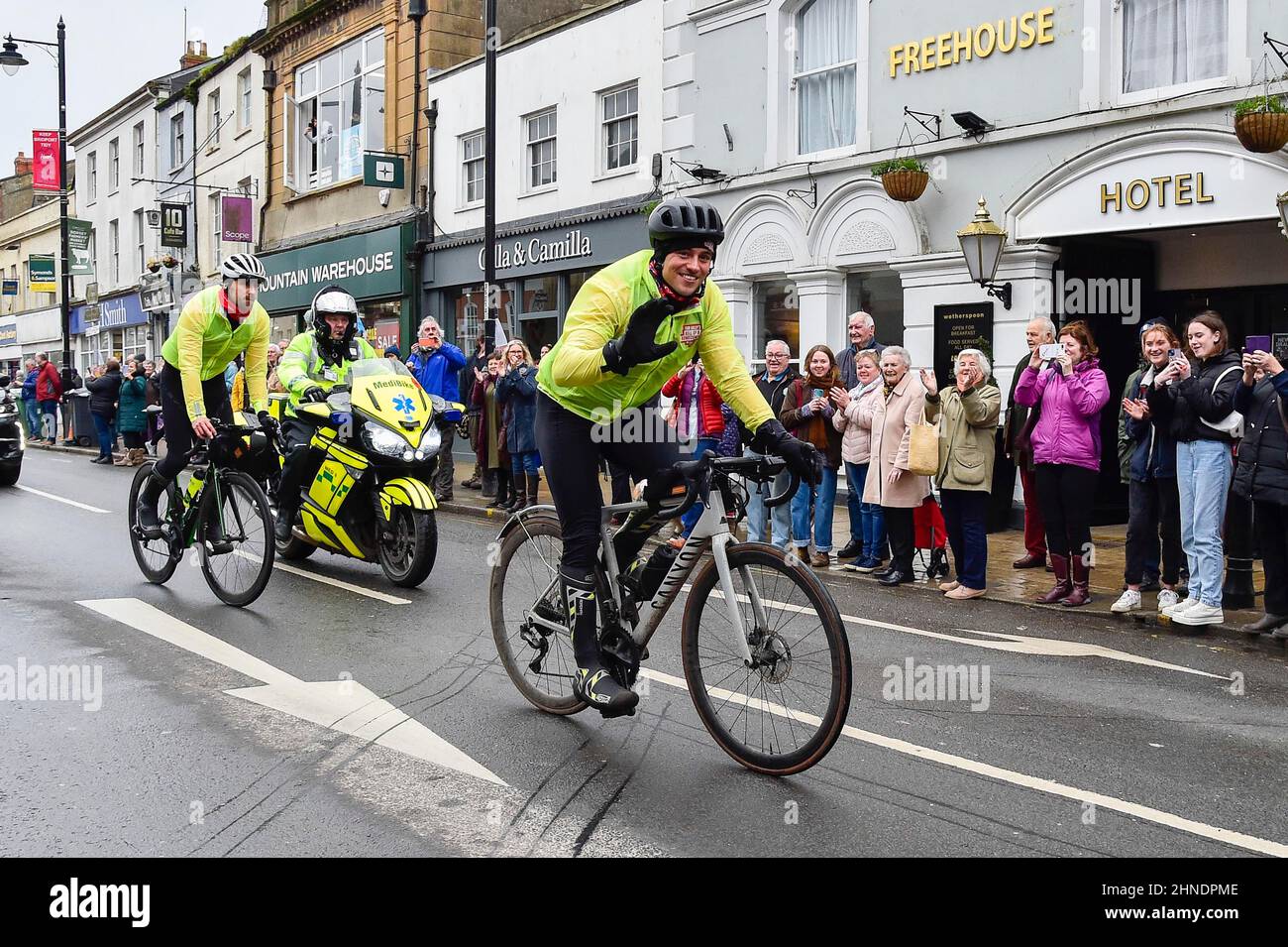 Bridport, Dorset, UK.  16th February 2022.  Olympic gold medalists Tom Daley OBE is cheered on by people lining the street as he rides through Bridport in Dorset on day 3 of his Comic Relief Hell of a Homecoming challenge from the Queen Elizabeth Olympic Park in Stratford to his hometown of Plymouth in Devon.  On this leg he is cycling 130 miles from Southampton to Bovey Castle on Dartmoor in Devon.  Picture Credit: Graham Hunt/Alamy Live News Stock Photo