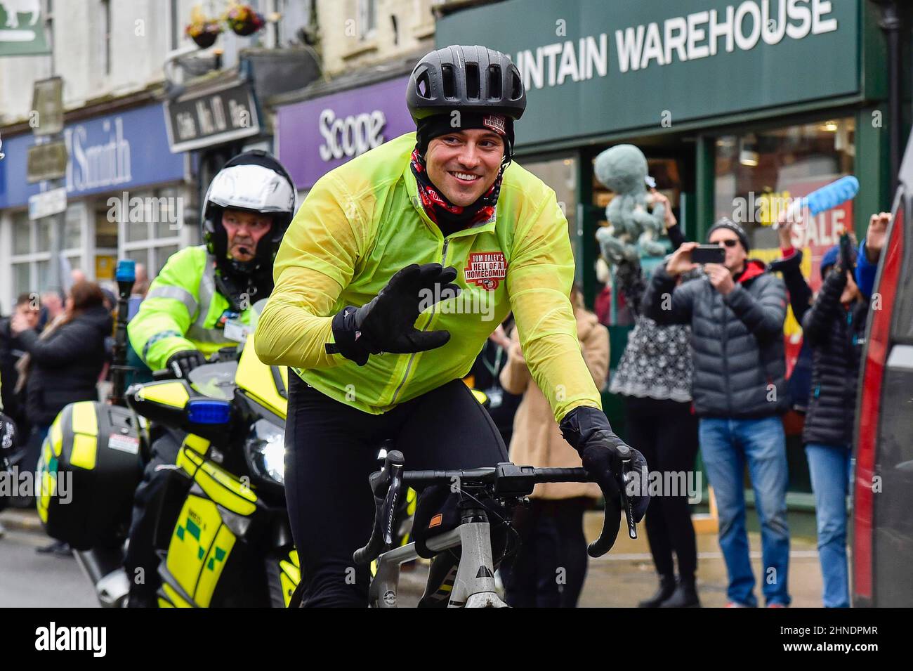 Bridport, Dorset, UK.  16th February 2022.  Olympic gold medalists Tom Daley OBE is cheered on by people lining the street as he rides through Bridport in Dorset on day 3 of his Comic Relief Hell of a Homecoming challenge from the Queen Elizabeth Olympic Park in Stratford to his hometown of Plymouth in Devon.  On this leg he is cycling 130 miles from Southampton to Bovey Castle on Dartmoor in Devon.  Picture Credit: Graham Hunt/Alamy Live News Stock Photo