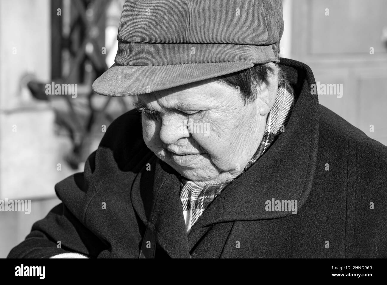 Poznan, Poland - A pensioner, the face of an elderly woman in a cap and coat. Sharp make-up. Stock Photo