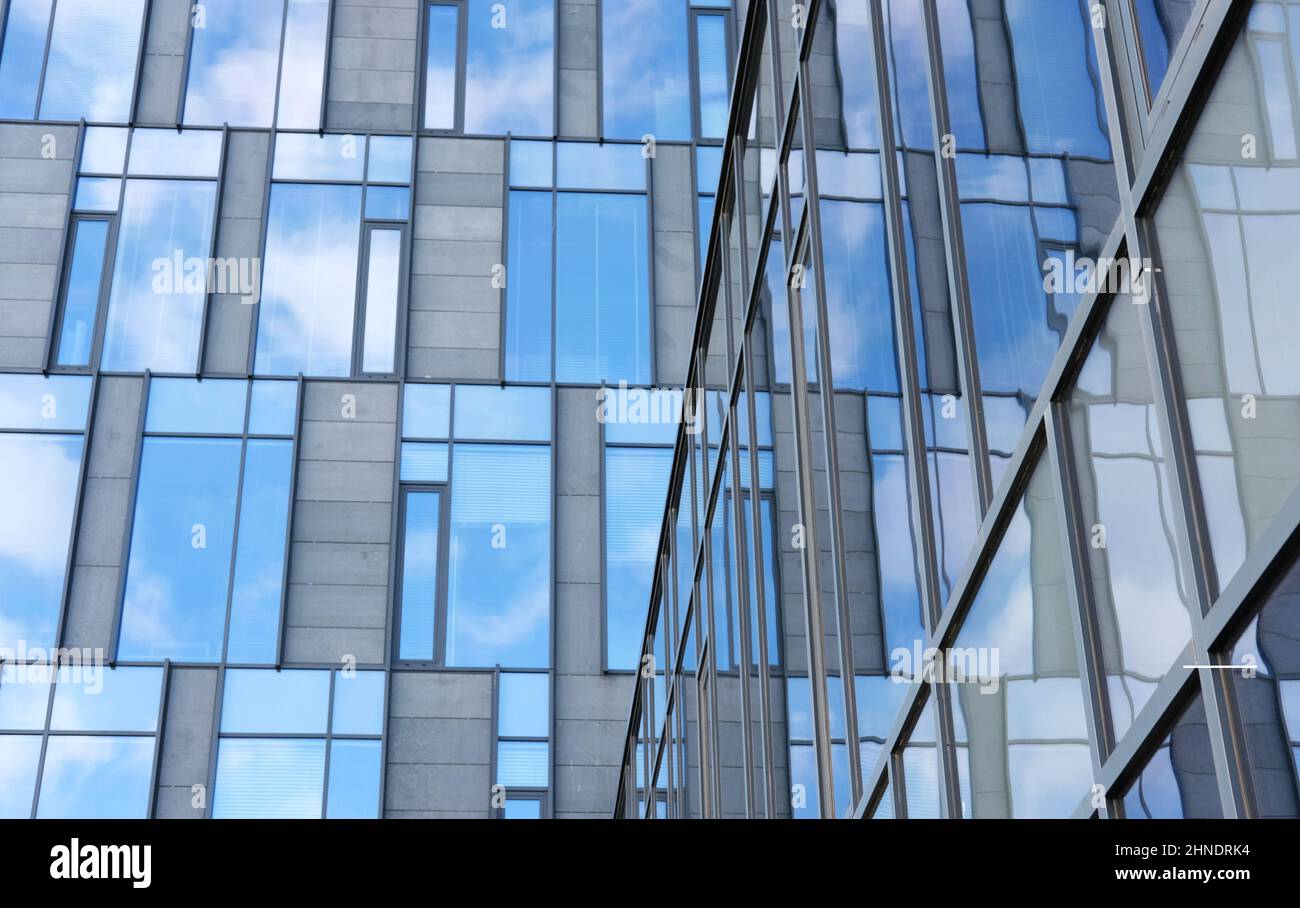 modern office building with glass facade reflecting blue sky - color ...