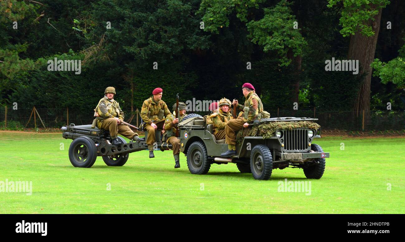 World War 2 Jeep pulling a Field Gun with men dressed as World War 2 British soldiers in red berets. Stock Photo