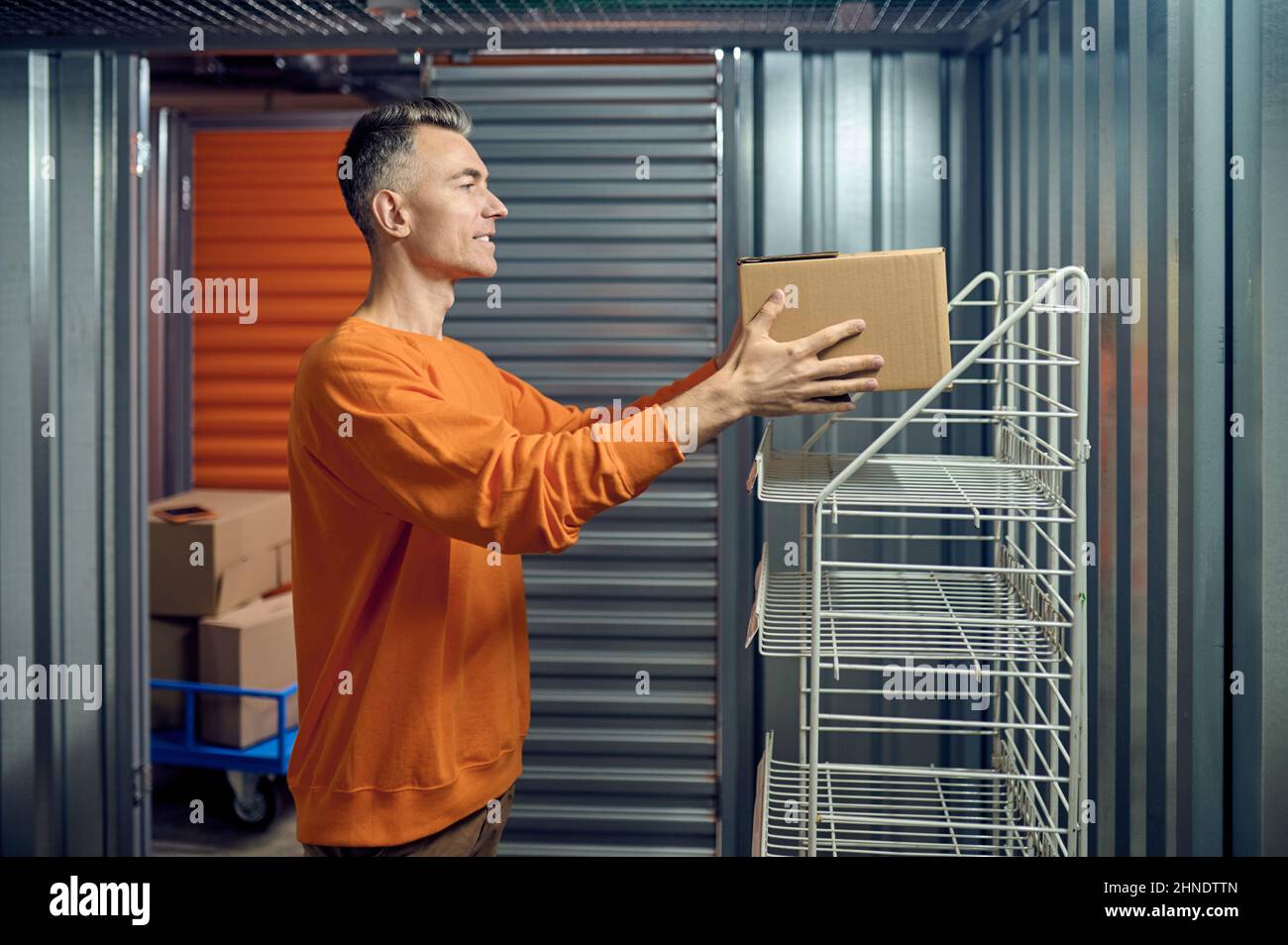 Worker arranging boxed goods in the storage room Stock Photo - Alamy