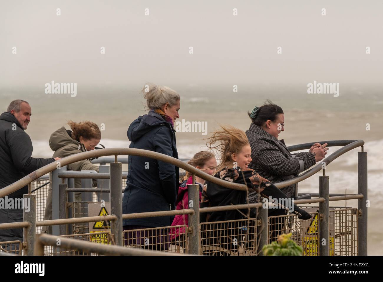 16th February, 2022. UK WEATHER - a family look at the sea as  gale force winds pound Birling Gap East Sussex, UK Credit: reppans/Alamy Live News Stock Photo