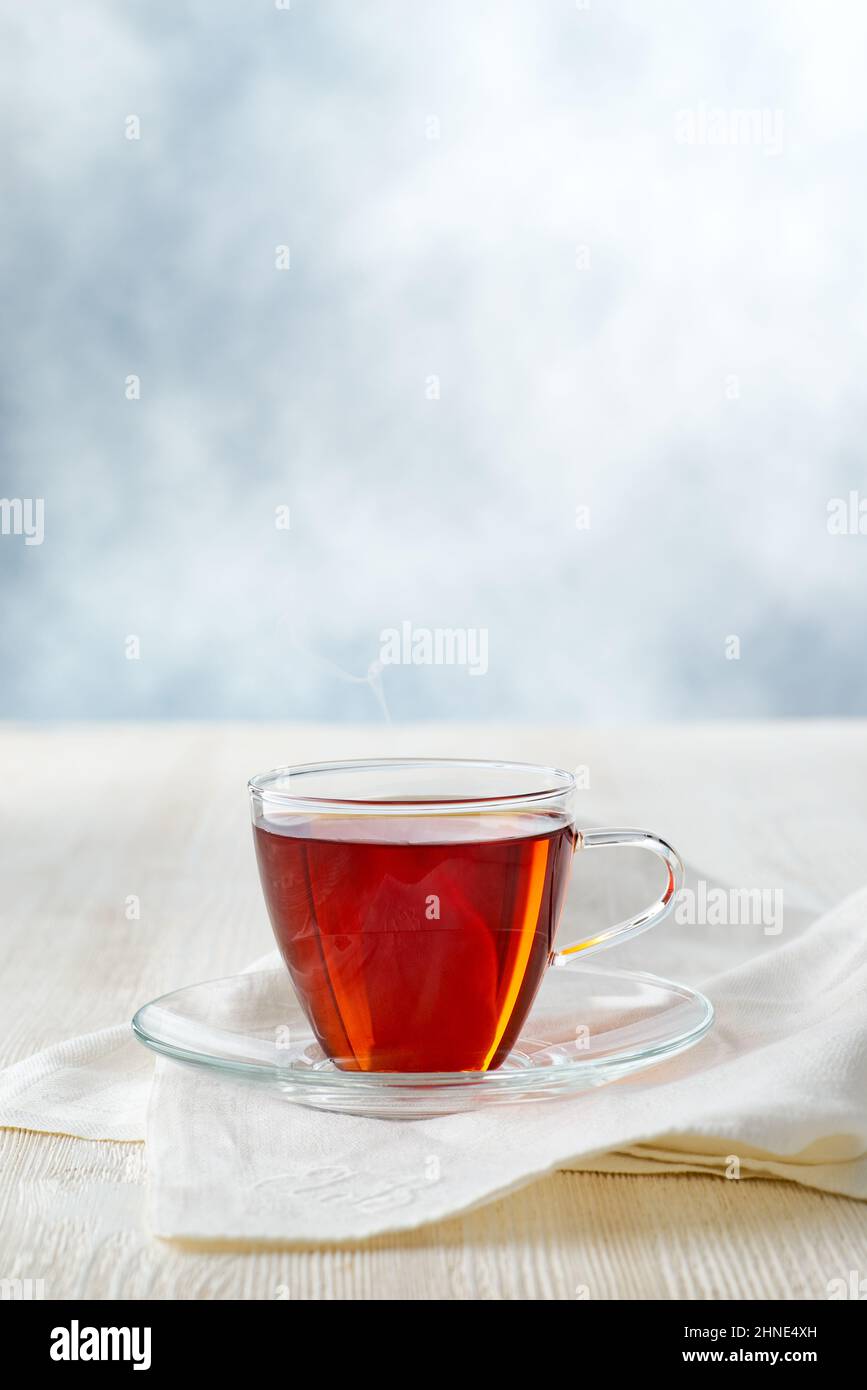 Glass cup of black tea on white wooden table Stock Photo