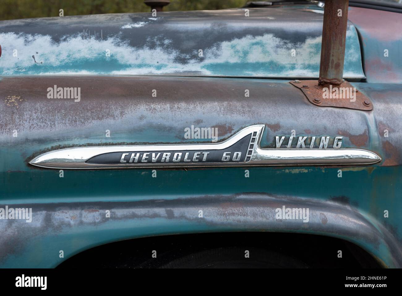Emblem on a Chevrolet 60 Viking truck, the metal on the pickup a greenish blue and brown patina. Stock Photo