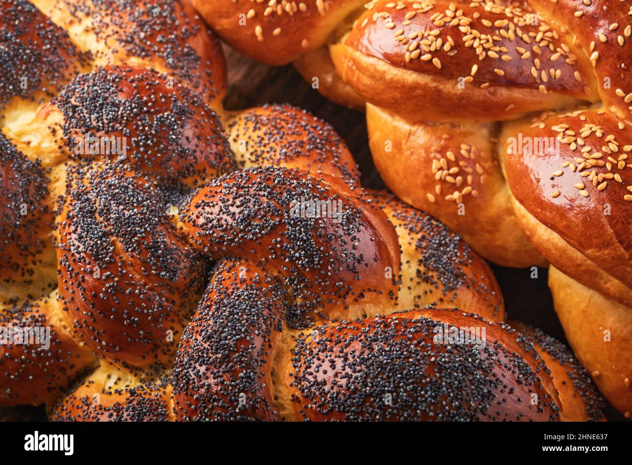 Shabbat Shalom. Bread challah with sesame seeds and poppy seeds on wooden background