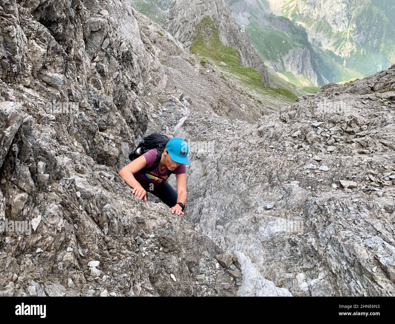 Woman climbing up to peak of Gottvater in Raetikon mountains. Vorarlberg, Austria. High quality photo Stock Photo