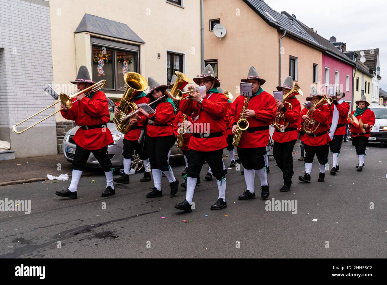 Bornheim, North Rhine-Westphalia, Germany - February 22, 2020: Brass band playing traditional carnival music and marching in red costumes at a parade. Stock Photo