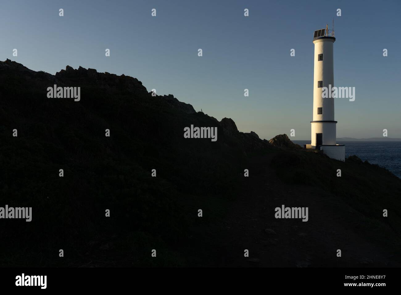 Cabo (cape) Home lighthouse on the cliffs at sunset in Rias Baixas zone in Galicia coast. Stock Photo